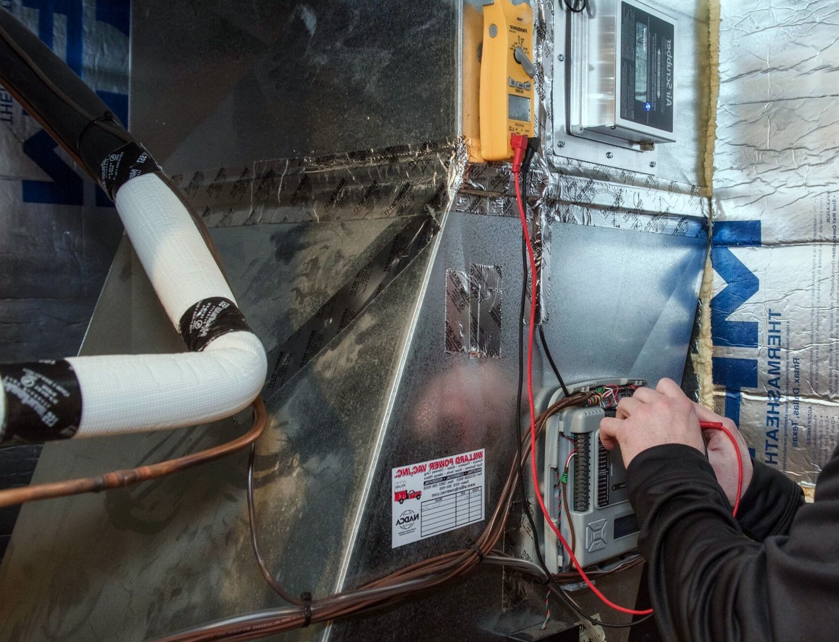 The gas furnace installer checks the operation of the heating system.