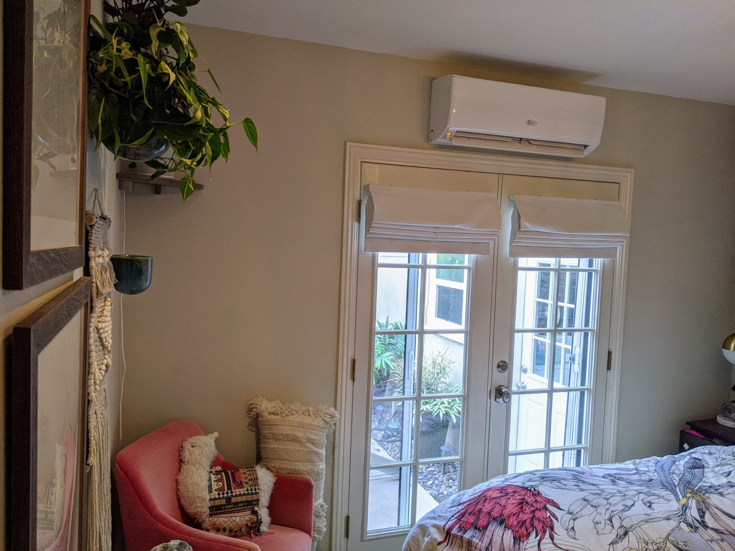 White wall-mounted mini-split AC mounted above a wooden door with glass inserts.