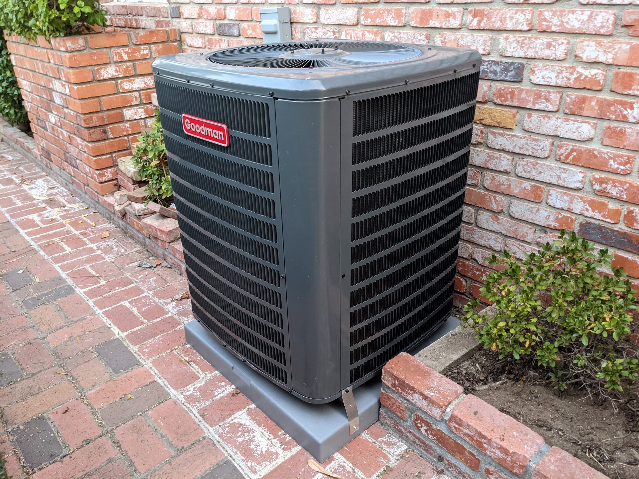 Goodman AC installed near a brick wall