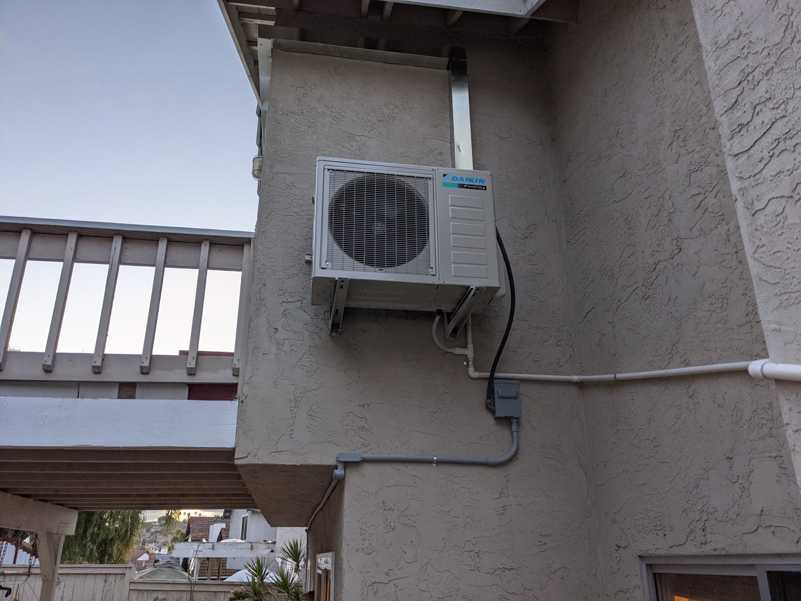 Daikin mini split AC outdoor unit mounted on the wall.