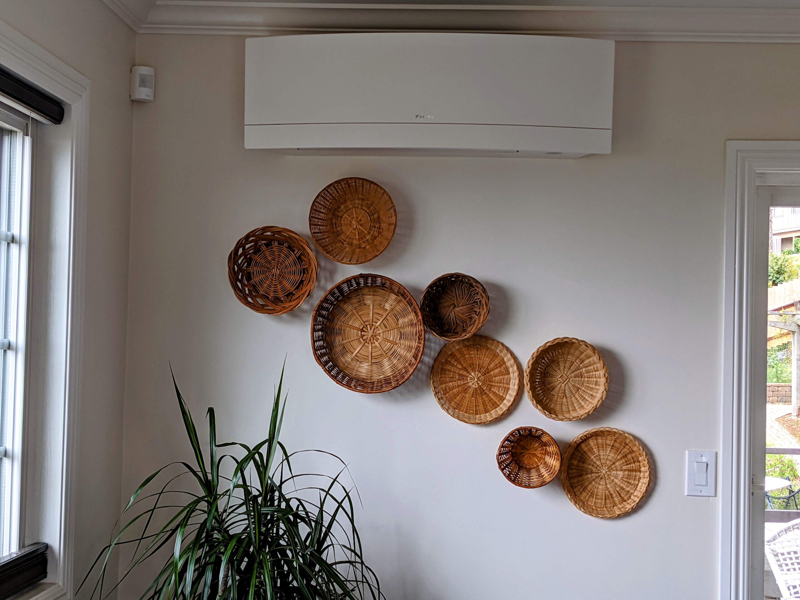 Wall mounted indoor ductless air conditioner installed above baskets collection in a living room.