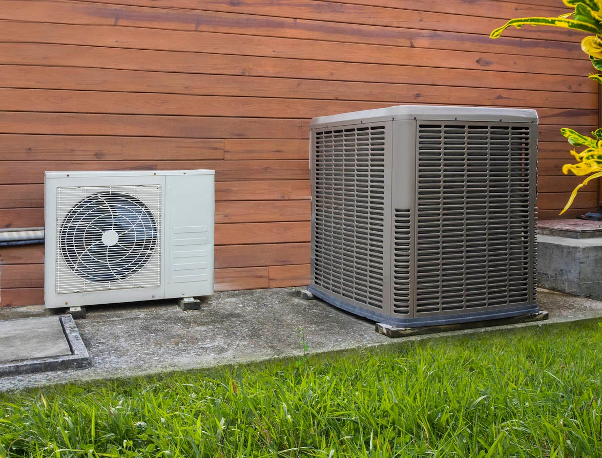 AC and heat pump beside house.